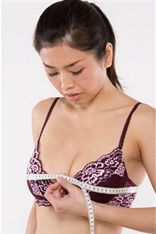 Asian woman measuring breasts